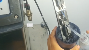 Technician performing maintenance on a Videojet 1000 Series continuous inkjet (CIJ) printer, carefully cleaning printer components to troubleshoot recovery failure and restore proper operation.
